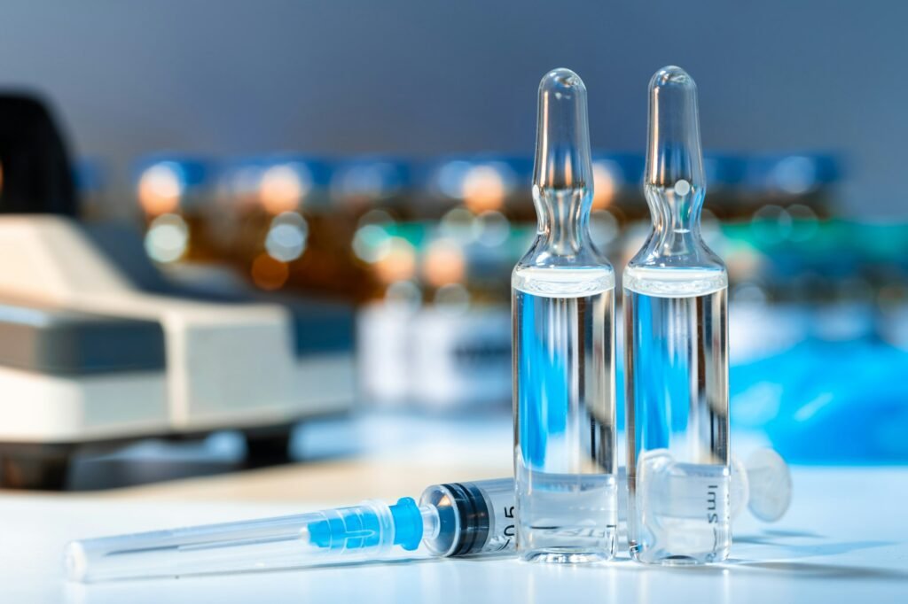 Vial of vaccine bottle with a syringe close up