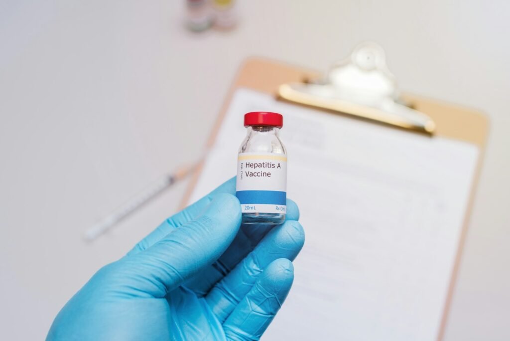 hepatitis a vaccination concept doctor with blue gloves holding vial of hepatitis A vaccine