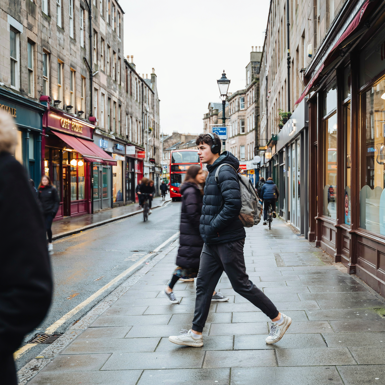 University student with headphones and backpack walking through Edinburgh city centre &mdash; Edinburgh Vaccination Clinic on Bruntsfield Place is easily reached by bus from all main Edinburgh university campuses
