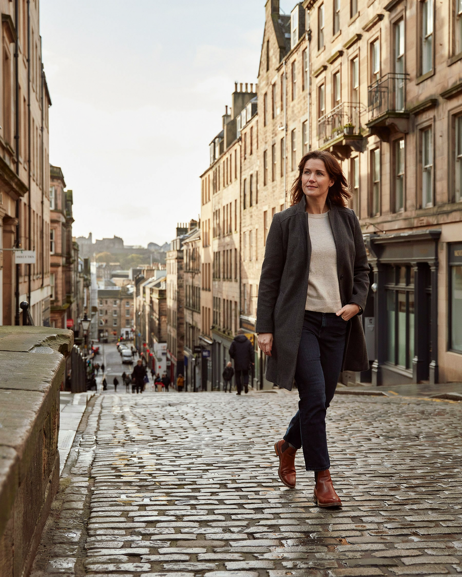 Woman stepping out of a pharmacy onto an Edinburgh street after her Mounjaro consultation at Edinburgh Vaccination Clinic, Bruntsfield