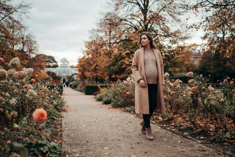 Pregnant woman walking through the gardens at Saughton Park in Edinburgh on a mild autumn afternoon, thinking about vaccination in pregnancy