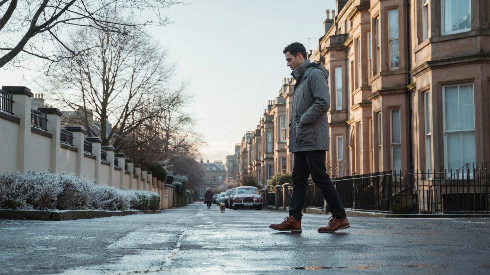 Adult walking along a quiet street of stone villas in the Grange, Edinburgh, on a frosty winter morning after a COVID-19 vaccine