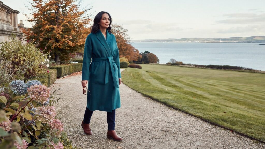 Adult walking through the gardens of Lauriston Castle in Edinburgh on a crisp autumn morning, the Firth of Forth beyond, during the 2026/27 COVID-19 vaccine season