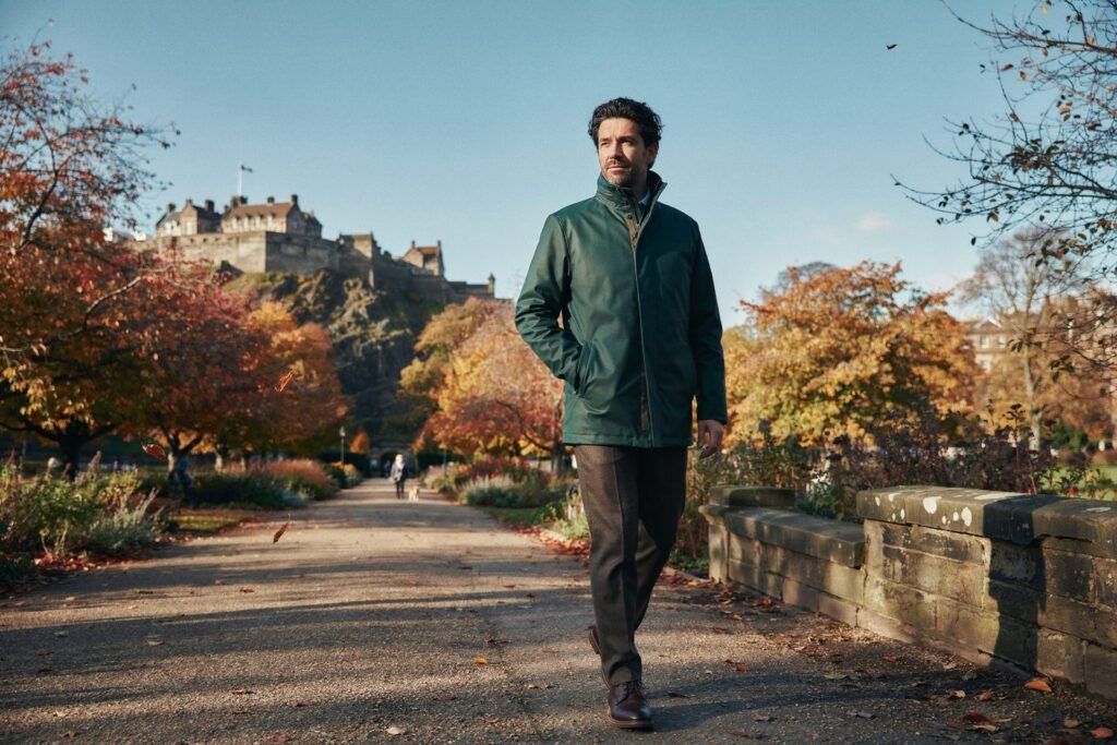 Adult walking through Princes Street Gardens in Edinburgh on a bright, cold morning with the castle behind, feeling well after a flu vaccine