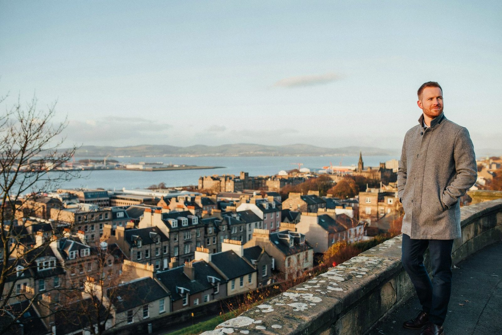 Adult pausing on Calton Hill in Edinburgh on a clear late autumn afternoon, looking across the city, protected for the winter ahead
